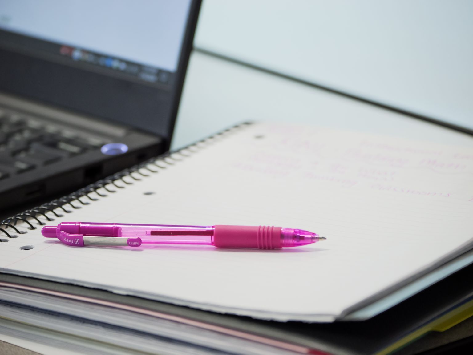Pen laying on top of a pad of paper.
