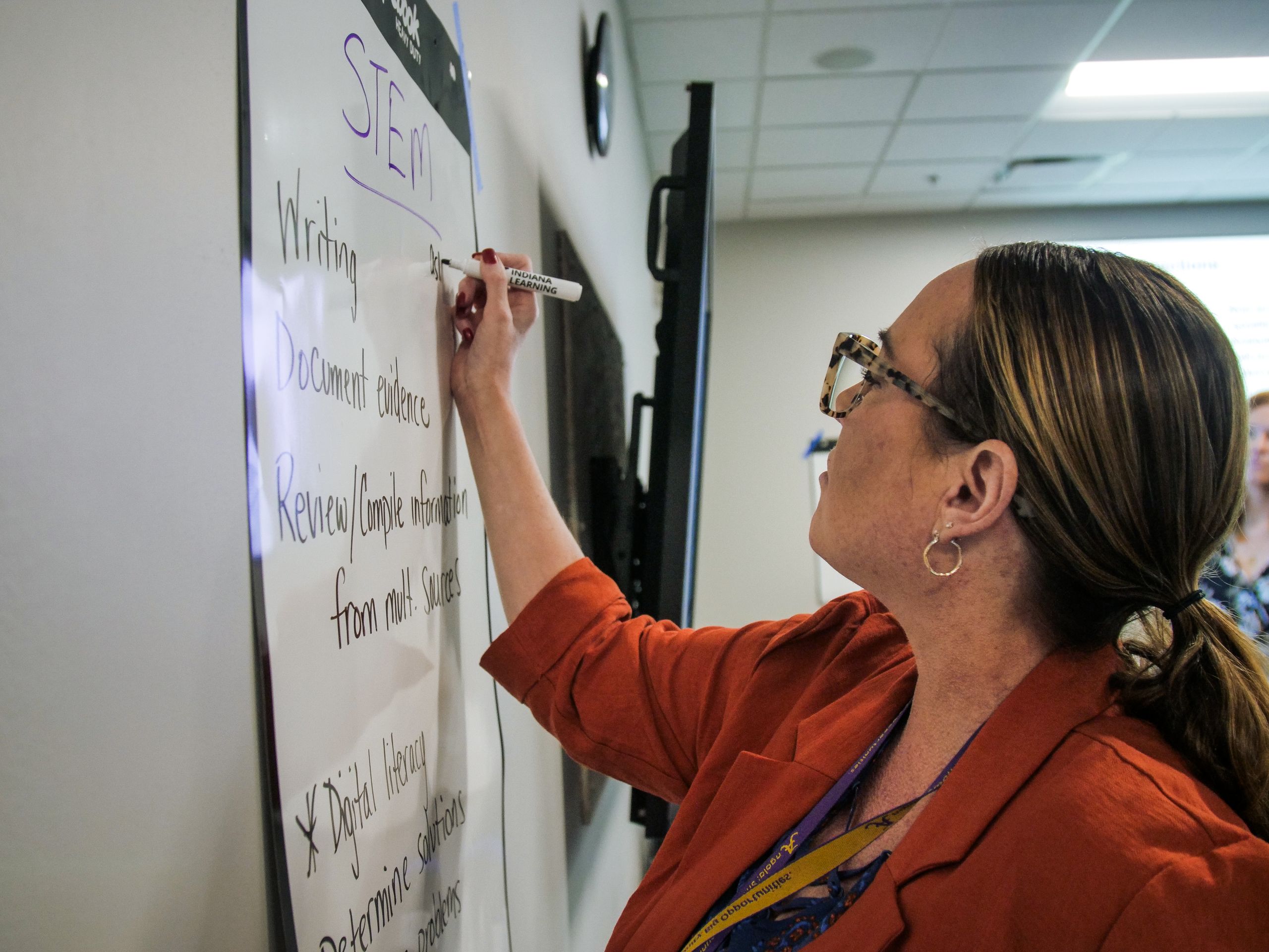 KINL Team Member writing on a whiteboard.