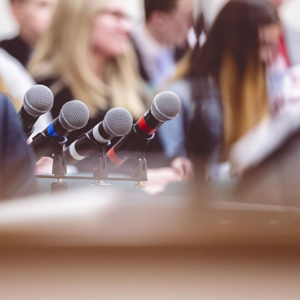 Selective focus shot of microphones next to a rostrum on a stage