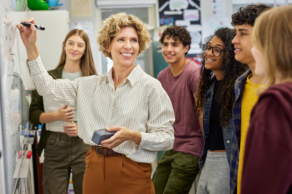 Educator in classroom Teacher at a whiteboard with students